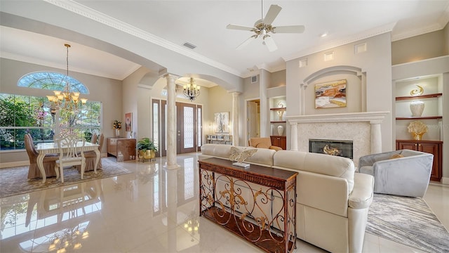 living room with ornate columns, ornamental molding, a fireplace, and built in shelves