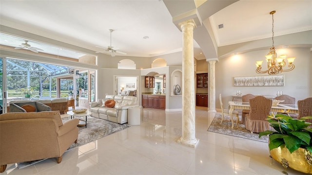 living room featuring ornate columns, ornamental molding, a towering ceiling, and ceiling fan with notable chandelier