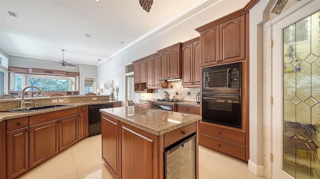 kitchen with sink, light stone counters, black appliances, a kitchen island, and beverage cooler