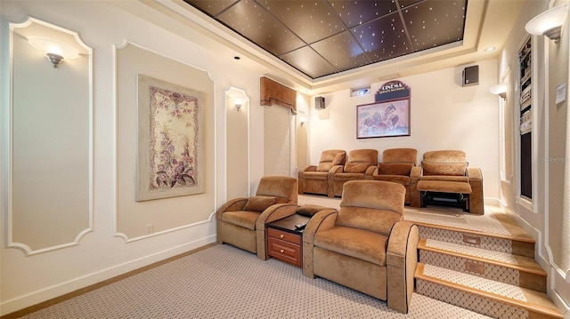 home theater room with a raised ceiling and light colored carpet