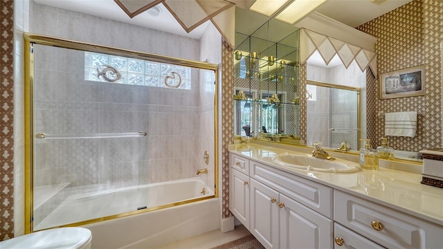 full bathroom with vanity, toilet, and combined bath / shower with glass door