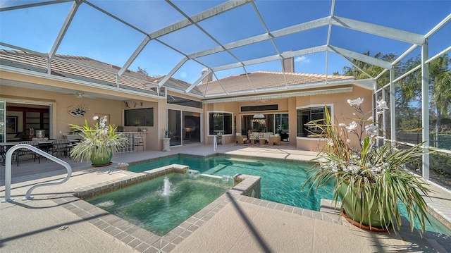 view of swimming pool with exterior bar, an in ground hot tub, ceiling fan, glass enclosure, and a patio area