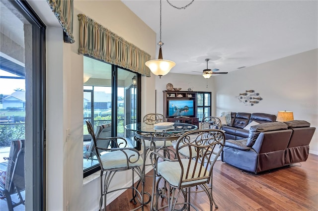 dining area with wood-type flooring and ceiling fan