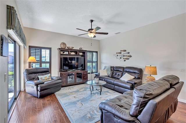 living room with hardwood / wood-style flooring, a wealth of natural light, and a textured ceiling