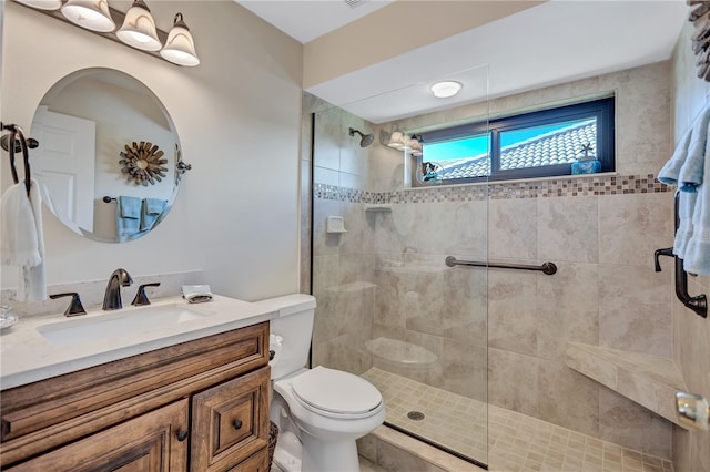 bathroom featuring vanity, toilet, and tiled shower