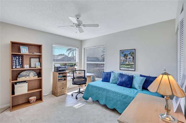 carpeted office featuring ceiling fan and a textured ceiling