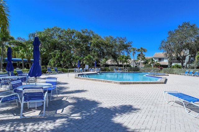 view of pool with a hot tub and a patio area