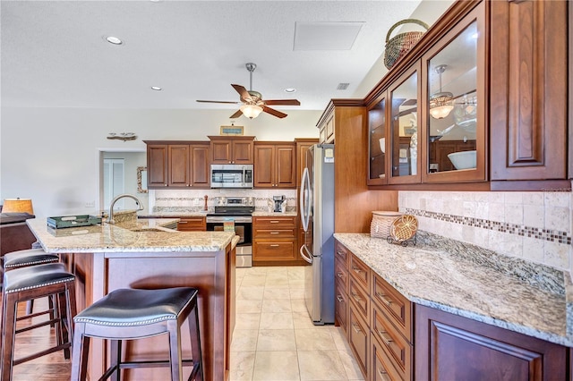 104 Inlets Blvd Unit 104, Nokomis, FL 34275 - kitchen featuring stainless steel appliances, a sink, backsplash, a kitchen bar, and a ceiling fan