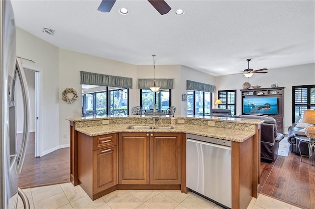 104 Inlets Blvd Unit 104, Nokomis, FL 34275 - kitchen with stainless steel appliances, ceiling fan, open floor plan, brown cabinets, and recessed lighting