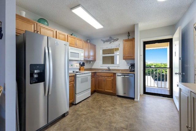 kitchen featuring appliances with stainless steel finishes, sink, and a textured ceiling