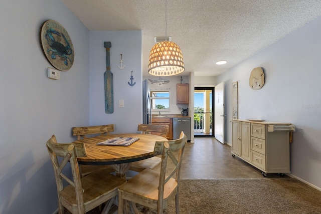 dining room with carpet and a textured ceiling