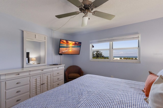 bedroom featuring ceiling fan and a textured ceiling