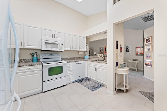 5618 Monte Rosso Rd, Sarasota, FL 34243 - kitchen featuring a high ceiling, white cabinetry, sink, and white appliances