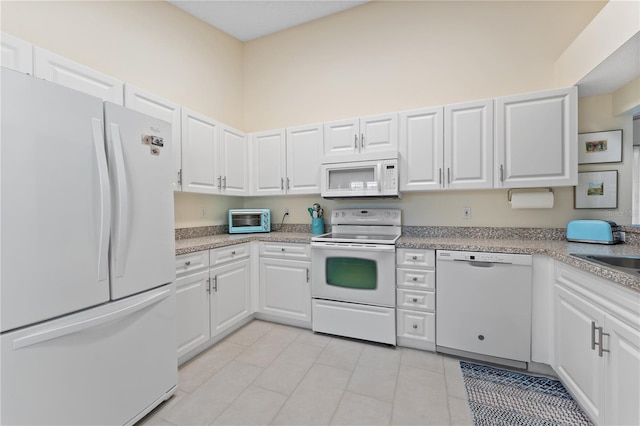 5618 Monte Rosso Rd, Sarasota, FL 34243 - kitchen featuring white cabinetry, sink, light tile patterned floors, and white appliances