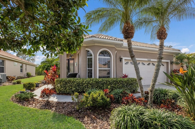 mediterranean / spanish home featuring a garage and a front lawn