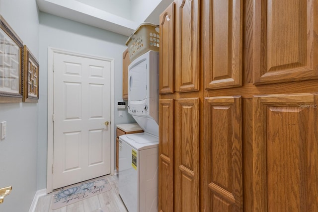 washroom with stacked washer and dryer and cabinets