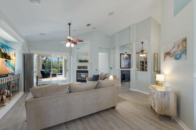 living room with high vaulted ceiling, decorative columns, ceiling fan, and light wood-type flooring