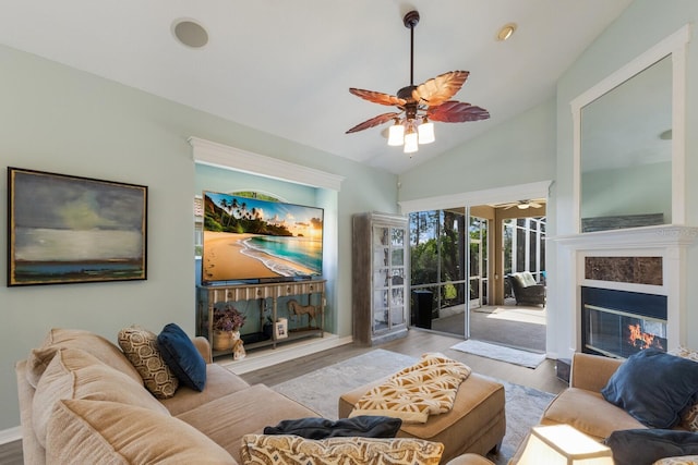 living room featuring ceiling fan, vaulted ceiling, and light wood-type flooring