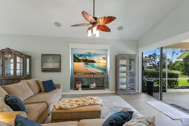 living room featuring vaulted ceiling, ceiling fan, and light wood-type flooring