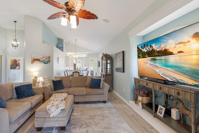 living room featuring high vaulted ceiling, ceiling fan with notable chandelier, and light hardwood / wood-style floors