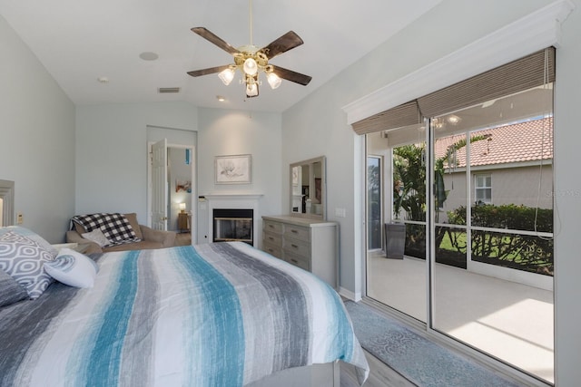 bedroom with ceiling fan, vaulted ceiling, and access to outside