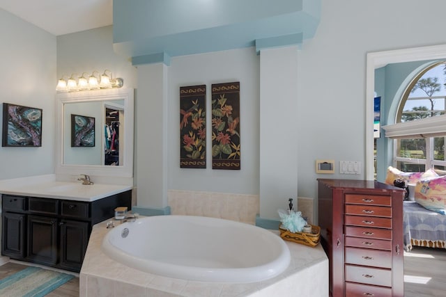 bathroom featuring vanity, hardwood / wood-style floors, and a relaxing tiled tub