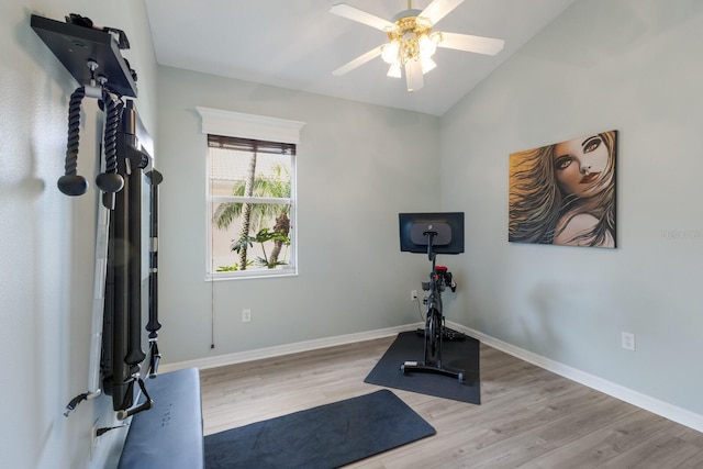 workout area featuring ceiling fan, vaulted ceiling, and light wood-type flooring