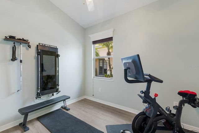 workout area with vaulted ceiling, light hardwood / wood-style floors, and ceiling fan