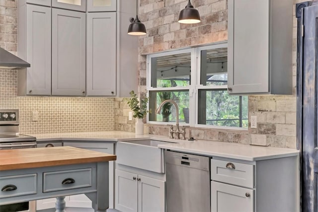 kitchen with tasteful backsplash, pendant lighting, appliances with stainless steel finishes, and a sink