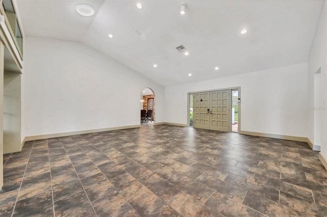 unfurnished living room with visible vents, baseboards, arched walkways, recessed lighting, and high vaulted ceiling