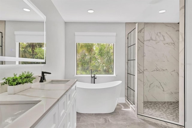 bathroom with a sink, a shower stall, a soaking tub, and plenty of natural light