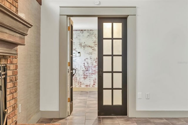 doorway featuring light tile patterned flooring, french doors, and baseboards