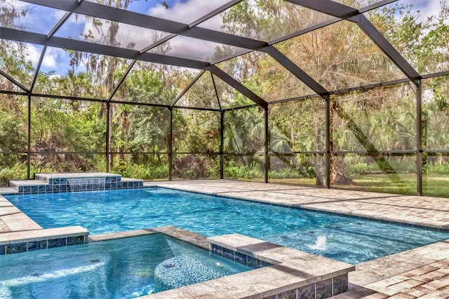 view of pool featuring glass enclosure and a pool with connected hot tub