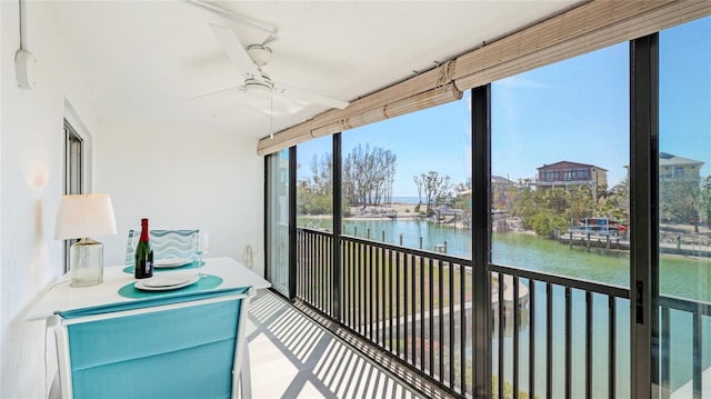 sunroom / solarium with a water view and ceiling fan