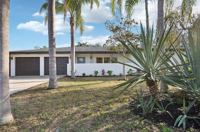 ranch-style house featuring a garage and a front lawn