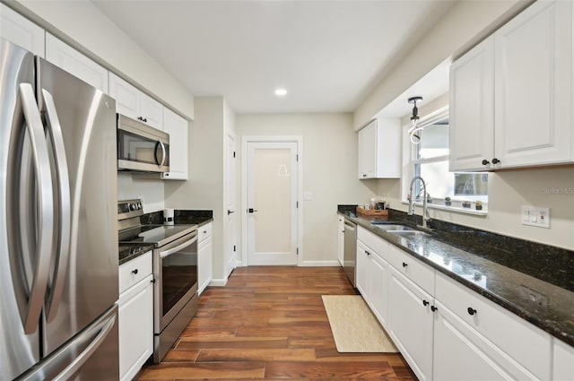 kitchen featuring sink, white cabinetry, dark stone counters, dark hardwood / wood-style floors, and stainless steel appliances