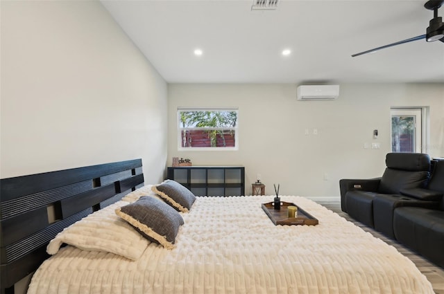 bedroom featuring hardwood / wood-style flooring, ceiling fan, and a wall mounted AC