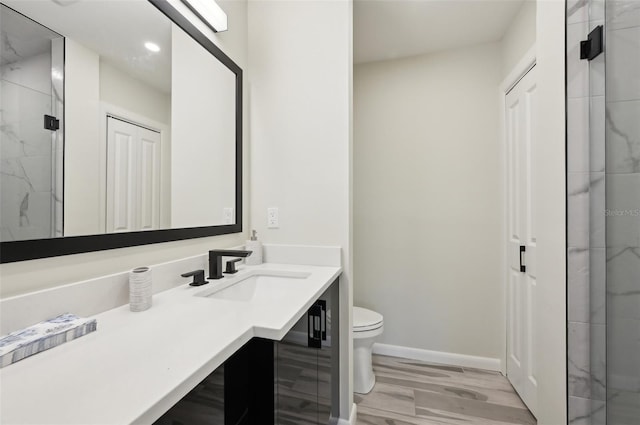 bathroom with vanity, a shower with shower door, wood-type flooring, and toilet