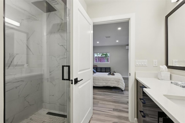 bathroom featuring hardwood / wood-style flooring, vanity, and a shower with door