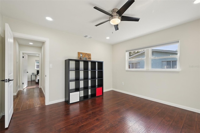 empty room featuring dark wood-type flooring and ceiling fan