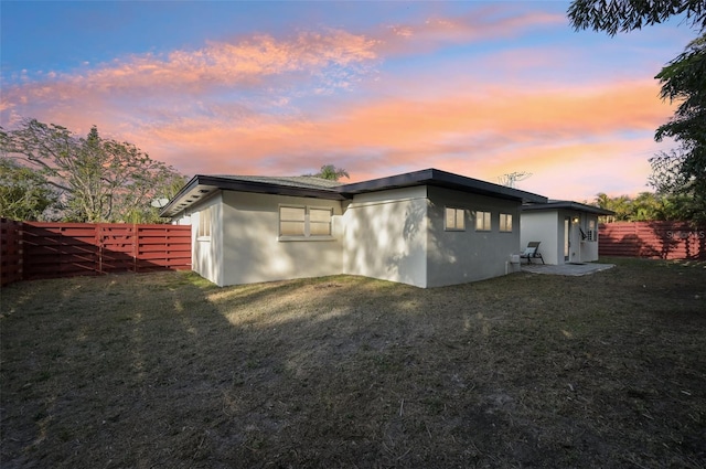 back house at dusk with a yard