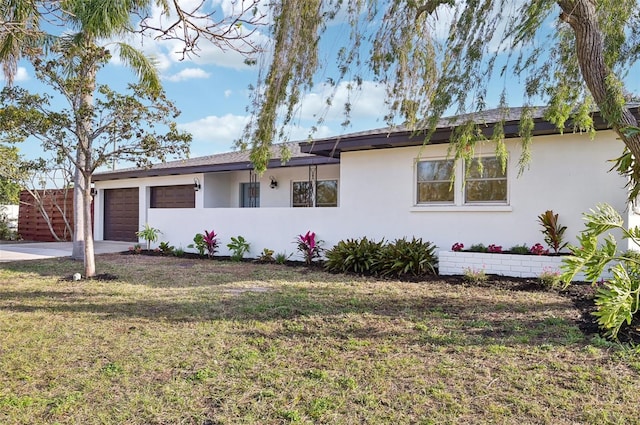 ranch-style home featuring a garage and a front lawn