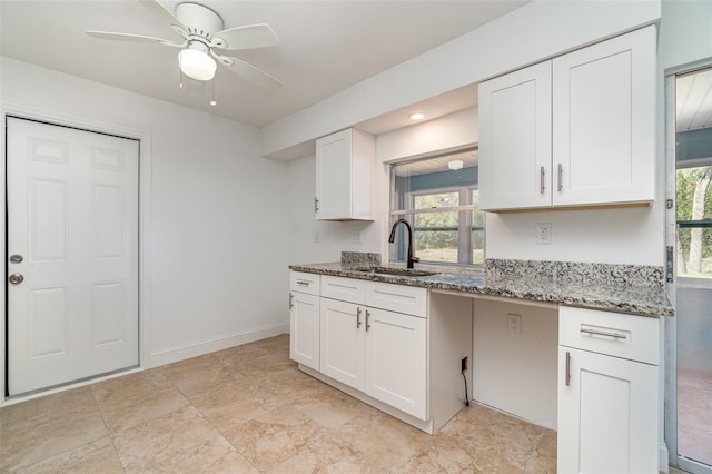 kitchen featuring sink, a healthy amount of sunlight, white cabinets, and stone counters