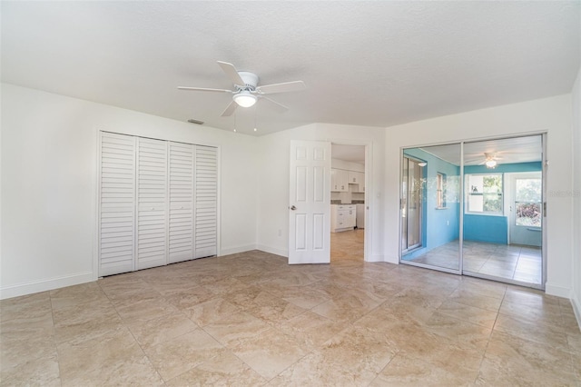 unfurnished bedroom with ceiling fan and a textured ceiling