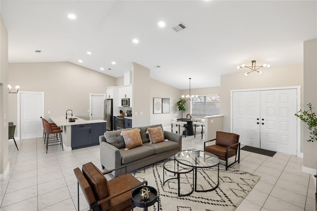 tiled living room featuring an inviting chandelier, lofted ceiling, and sink