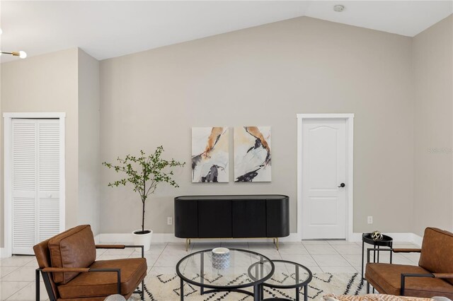 living area featuring vaulted ceiling and light tile patterned floors