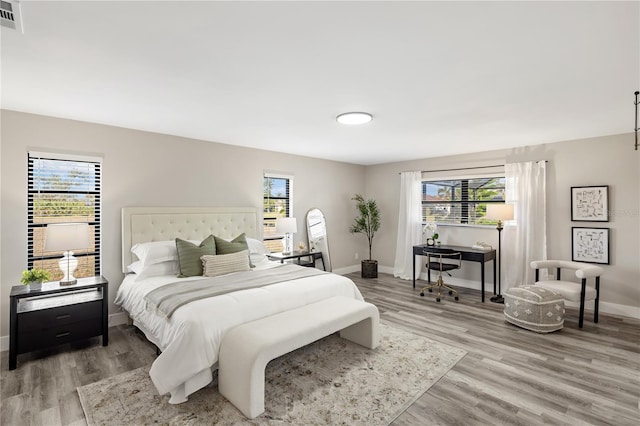 bedroom with multiple windows and hardwood / wood-style flooring