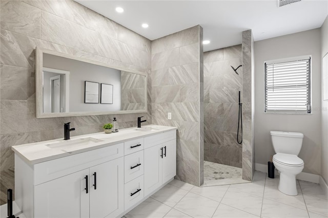 bathroom featuring tile walls, vanity, toilet, and tiled shower