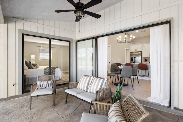 exterior space featuring ceiling fan with notable chandelier