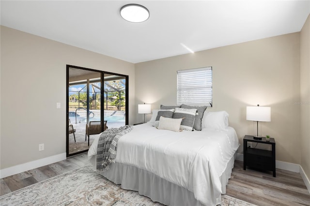 bedroom featuring access to exterior and light hardwood / wood-style flooring